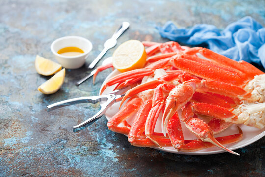 Snow crab legs plate with lemon and butter sauce, selective focus