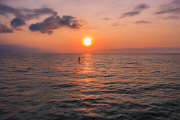 sunset over the sea with and paddle board