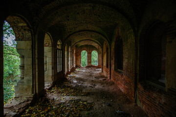 Dark corridor of old ancient abandoned red brick ruined historical building