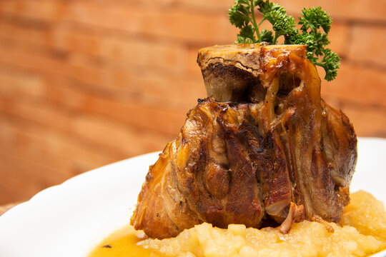 Stinco pork with green apple puree. Traditional Eisbein