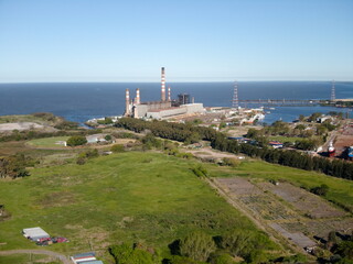 Fototapeta na wymiar Vista aérea de la zona sur del puerto de la ciudad, un parque y, al fondo, la planta generadora de energía eléctrica.