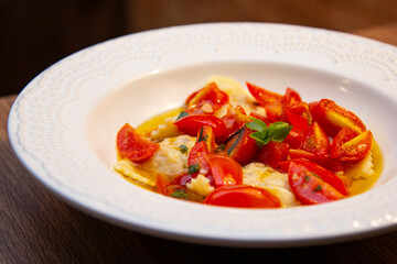 Ravioli with pieces of fresh tomato dipped in olive oil