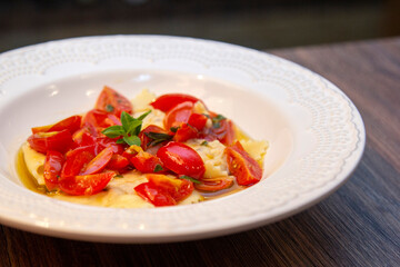 Ravioli with pieces of fresh tomato dipped in olive oil