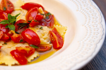Ravioli with pieces of fresh tomato dipped in olive oil