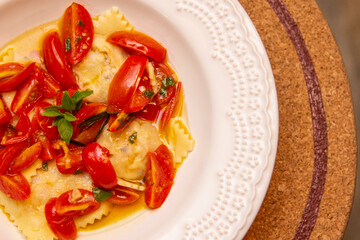 Ravioli with pieces of fresh tomato dipped in olive oil