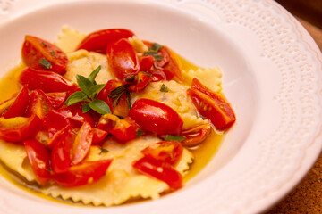 Ravioli with pieces of fresh tomato dipped in olive oil