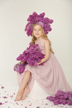 Little cute bright girl in the studio with lilac