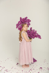 Little cute bright girl in the studio with lilac