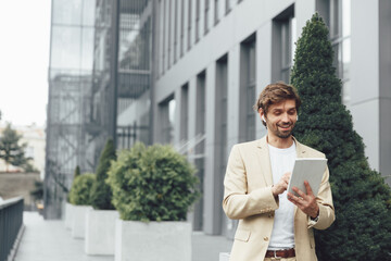 Smiling man in business suit having video call on tablet