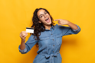 young hispanic woman smiling confidently pointing to own broad smile, positive, relaxed, satisfied...