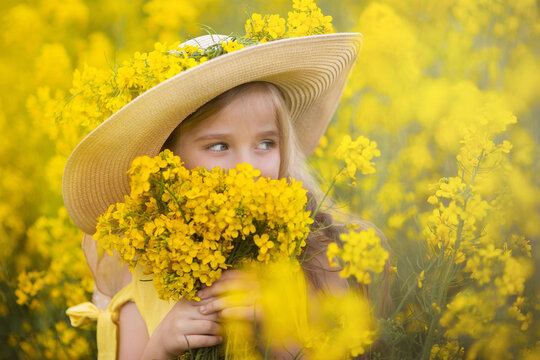 Little cute blonde girl on a rapeseed field