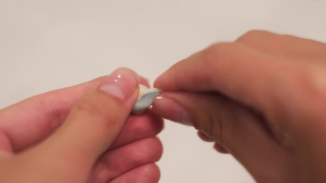 Woman holding earplugs isolated on white background. Concept. Close up of female hands holding soundproof soft earplugs and pressing on them with her fingers.