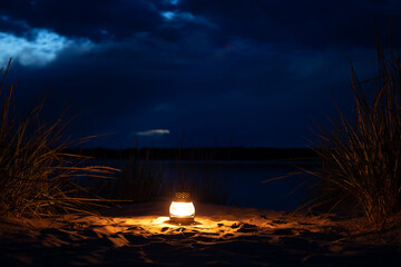 A lantern with a candle at night, romantic evening at the beach.