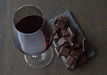 Red wine and chocolates on a wooden table