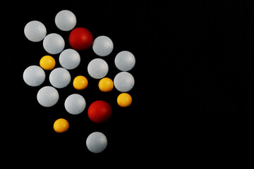 Blue red and yellow pills on black background. Concept for medical healt design. Covid 19.