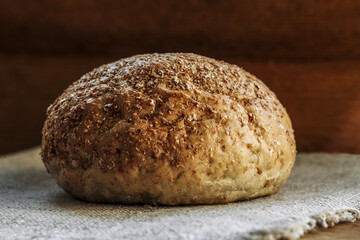 Homemade sourdough bread, loaf of freshly baked bread on a  linen napkin on a wooden background.