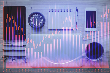 Double exposure of forex graph hologram over desktop with phone. Top view. Mobile trade platform concept.