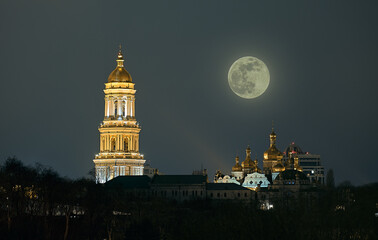 The yellow spotlight illuminates the church Pechersk Lavra. Kyiv, Ukraine. Laurel on the background of the night moon.