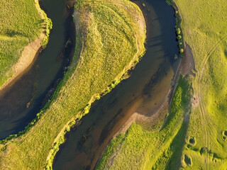 Aerial view of winding river. Summer landscape, top view. A green valley with a winding riverbed