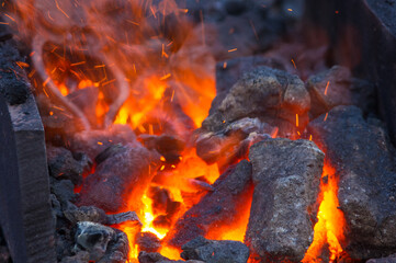 blacksmith furnace with burning coals, tools, and glowing hot metal workpieces