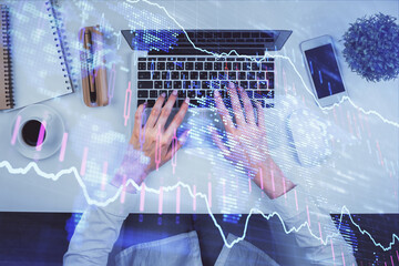 Double exposure of woman hands working on computer and forex chart hologram drawing. Top View. Financial analysis concept.