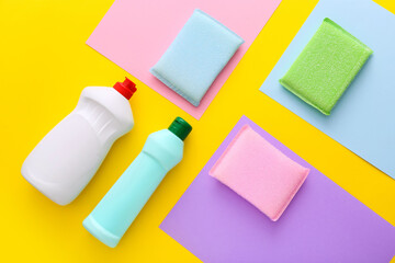 Colorful cleaning set for different surfaces in kitchen on yellow background. Top view, flat lay