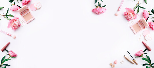 Beauty background with facial cosmetic products and peonies on white desktop background. Top view, flat lay.