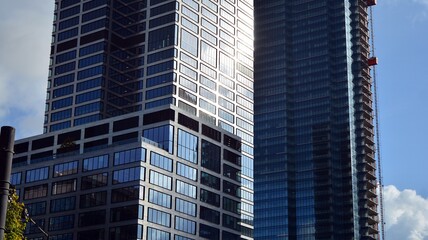 Obraz premium Blue curtain wall made of toned glass and steel constructions under blue sky. A fragment of a building.