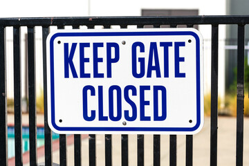 Keep Gate Closed warning sign on the entrance door to outdoor swimming pool to remind people to...