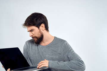 A man in a gray sweater with a laptop hands lifestyle technology communication internet work