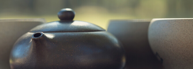 Naklejka na ściany i meble Chinese tea ceremony. Ceramic teapot made of clay and bowls on a wooden background.