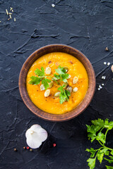 Delicious healthy pumpkin soup, herbs, and ingredients for the dish. Creative atmospheric decoration
