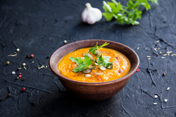 Delicious healthy pumpkin soup, herbs, and ingredients for the dish. Creative atmospheric decoration