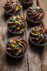 Tasty chocolate cupcakes on wooden background. Delicious dessert. Concept of sweet food.