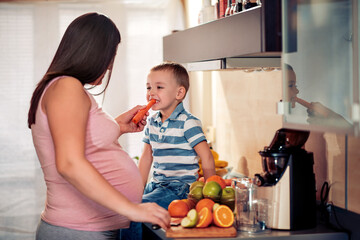 Family make fresh orange juice in the kitchen