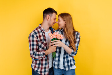 romantic couple, man and woman with a bouquet of flowers, on a yellow background, Valentine's Day