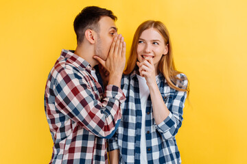 Portrait of young people, man and woman, gossiping on a white background