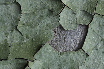 Peeling paint on the wall. Old concrete wall with cracked flaking paint. Weathered rough painted surface with patterns of cracks and peeling. Grunge texture for background and design. High resolution.