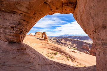 Delicate Arch seen through Twisted Doughnut Arch in Arches National Park, Utah