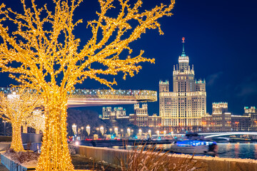 New Year Moscow. The soaring bridge and the Stalinist high-rise are festively lit. View from the embankment of the Moscow river to the city center. Christmas in the capital of Russia.