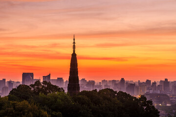 Naklejka premium Ancient Baochu Pagoda.Chinese traditional architecture and modern city skyline in Hangzhou at sunrise,China.