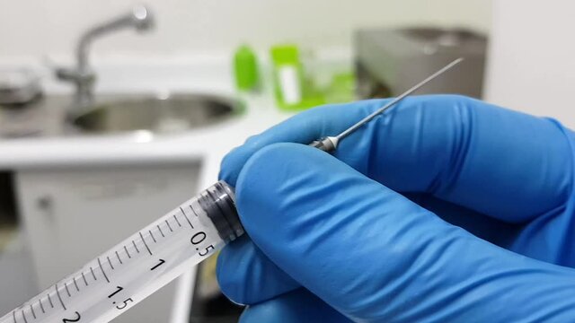 Doctor preparing syringe in medical setup. Vaccination concept 