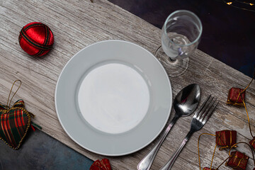 mesa para las fiestas de navidad y año nuevo con plato copa cubierto sobre madera y adornos...