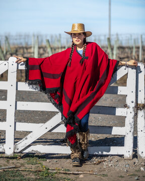 woman in a poncho on a fence