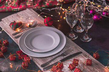 mesa para las fiestas de navidad y año nuevo con plato copa cubierto sobre madera y adornos...