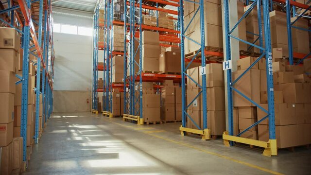 Gigantic Sunny Retail Warehouse full of Shelves with Goods in Cardboard Boxes. Logistics and Distribution Storehouse Center for further Product Delivery Packages. Slow Arc Camera View