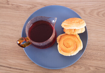 Black tea and small bread in blue plate