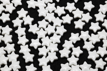 white sugar stars texture on black background