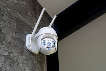 Round shape security camera hanging on wall.