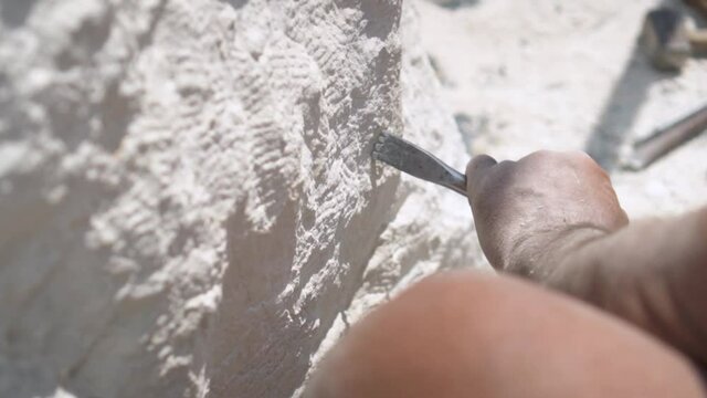 Stone Carving - Hands Of Stone Carver Carving White Stone With An Air Pneumatic Chisel On A Sunny Day.  - close up shot